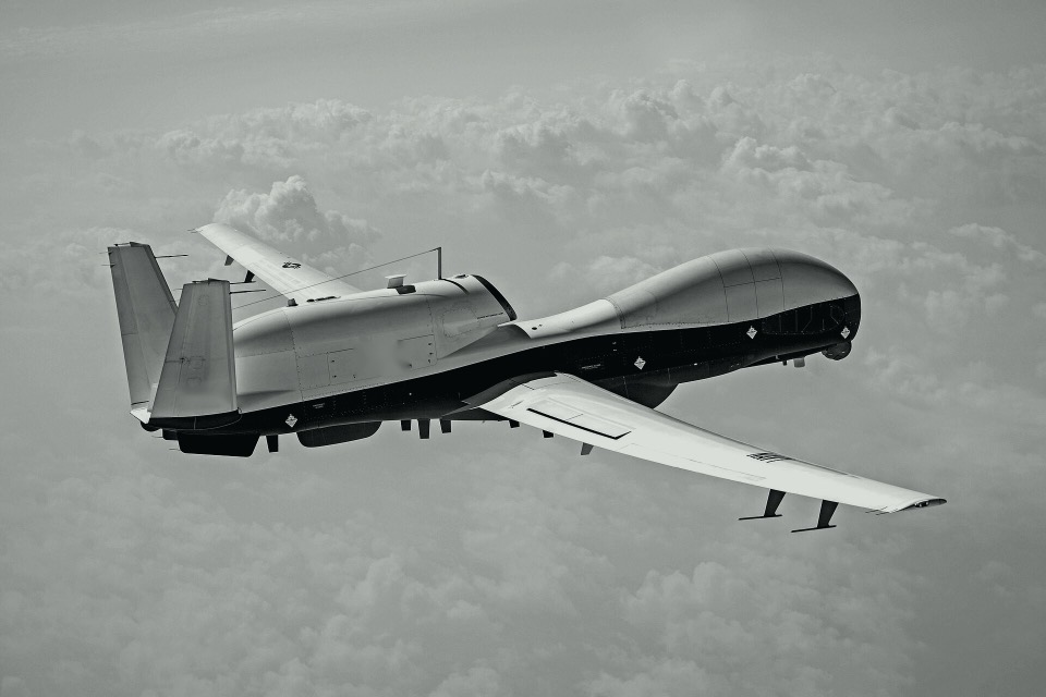 Uncrewed aircraft in flight, in black and white