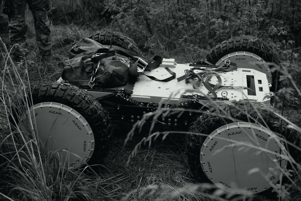 Uncrewed ground vehicle on rough ground, in black and white