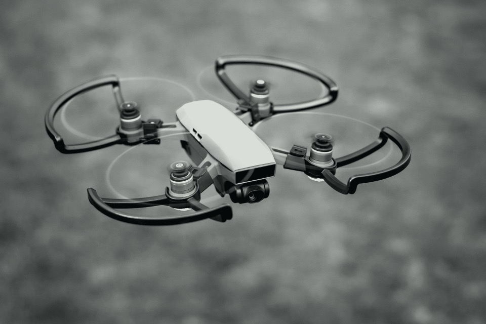 Small quadcopter in flight, in black and white