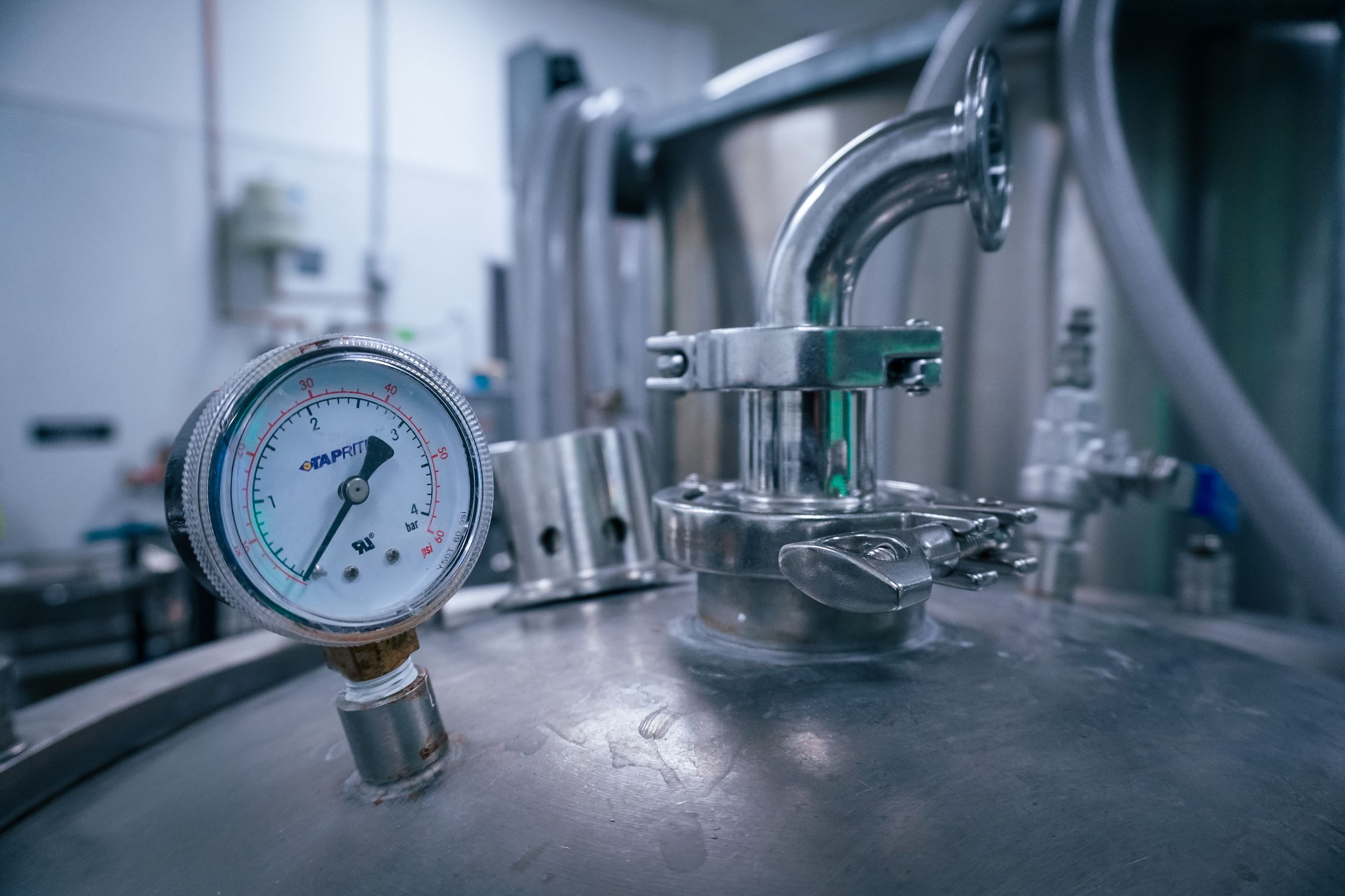 A pressure gauge mounted on stainless steel pipework in a clean process area.