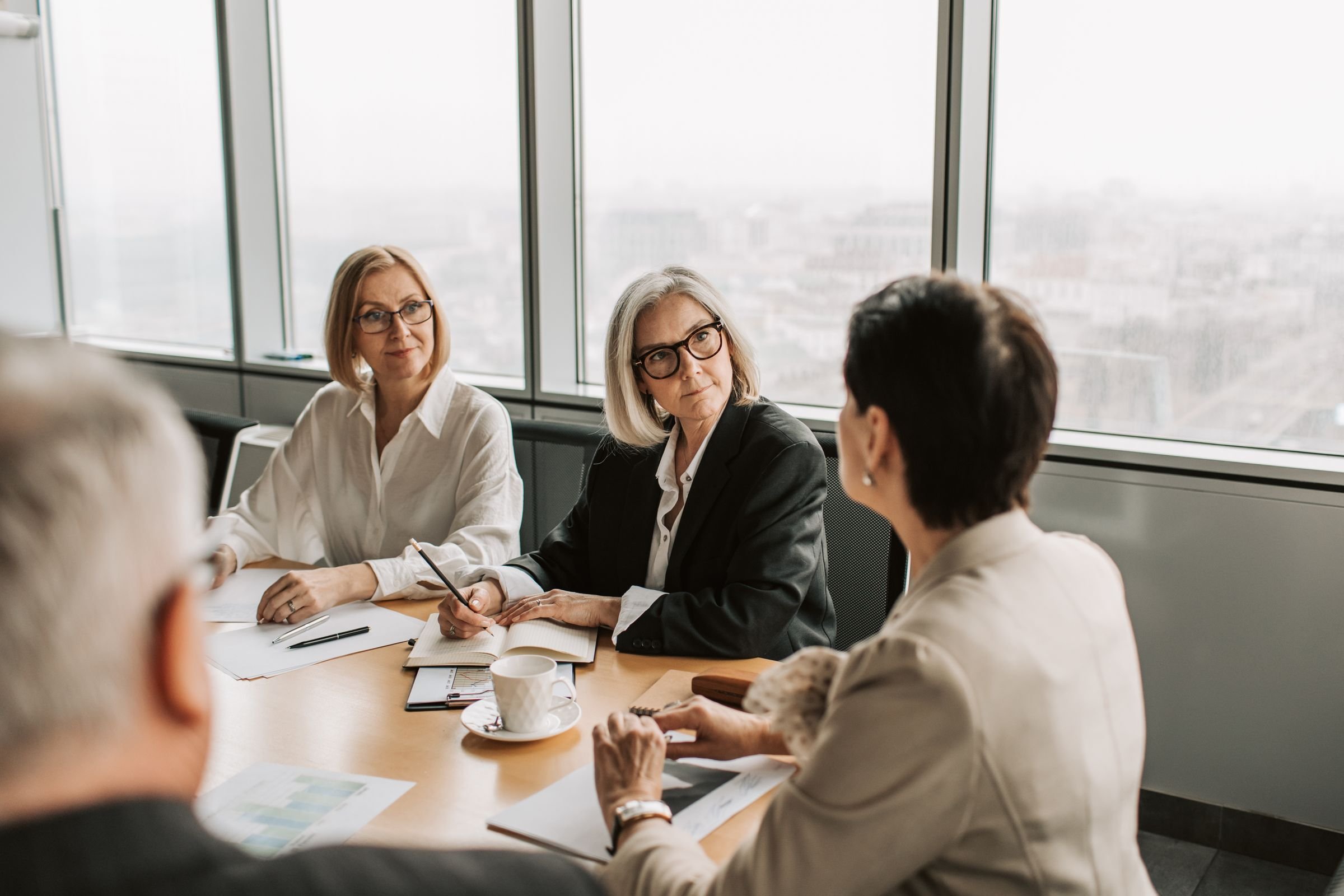 Colleagues in a strategy meeting at a table by a window