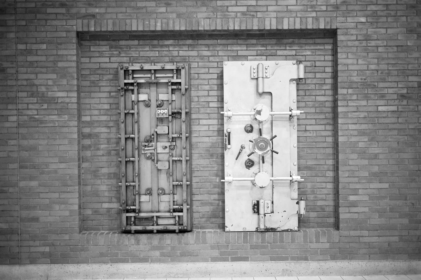 Two old steel vault doors set into a brick wall
