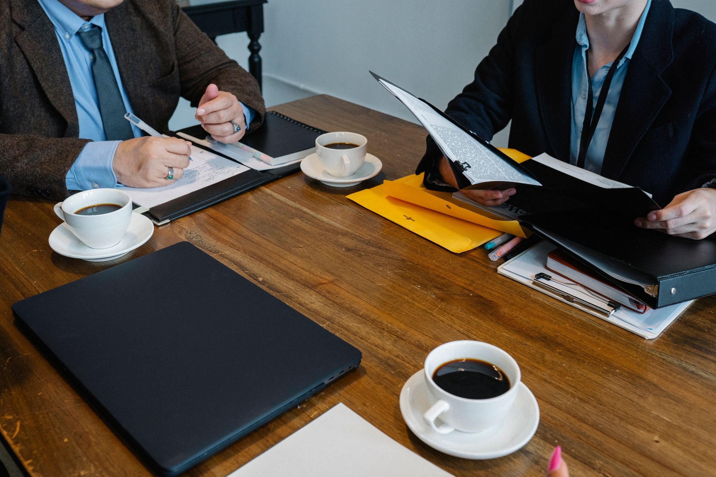 Colleagues reviewing documents together around a meeting table.
