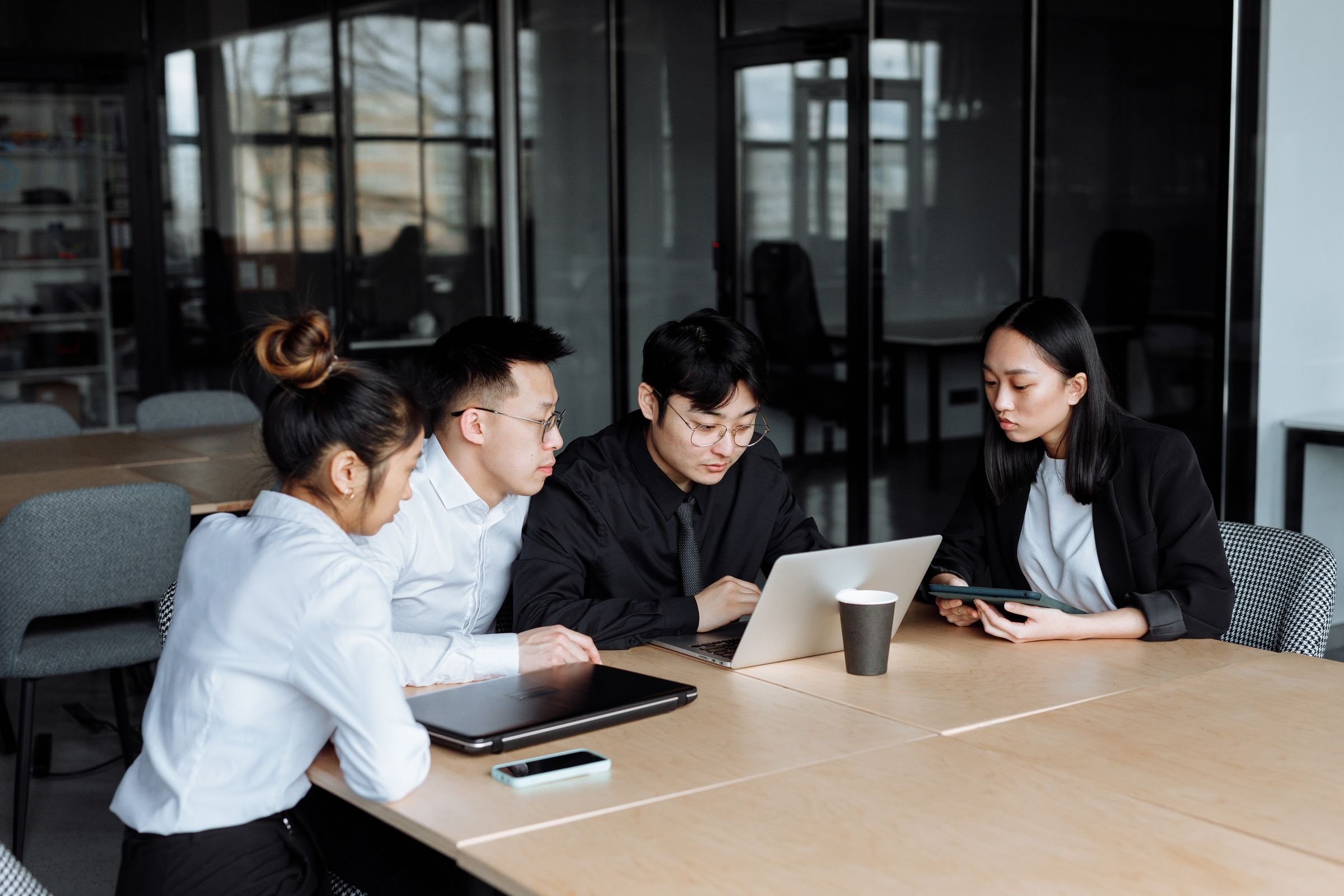 Colleagues working together at a table with a laptop