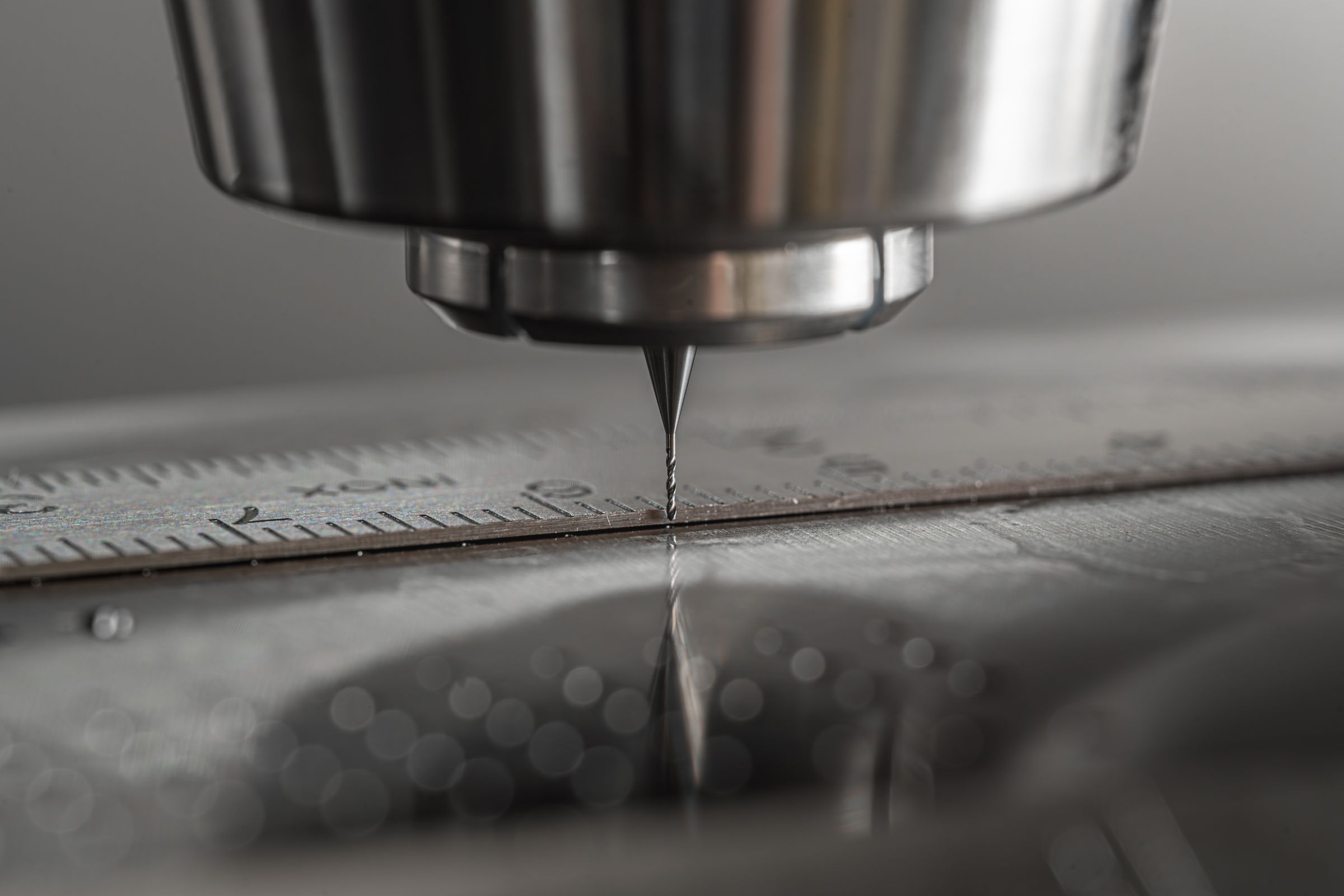 A CNC milling cutter close to a metal surface during machining.