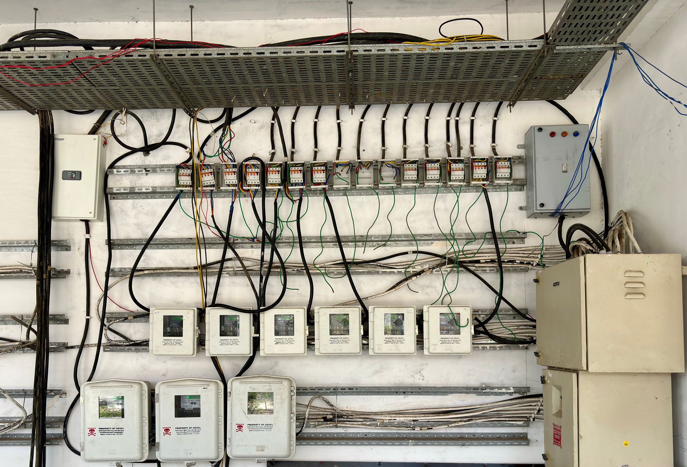 A wall-mounted control cabinet with cable trays, meters, junction boxes and bundles of wiring.