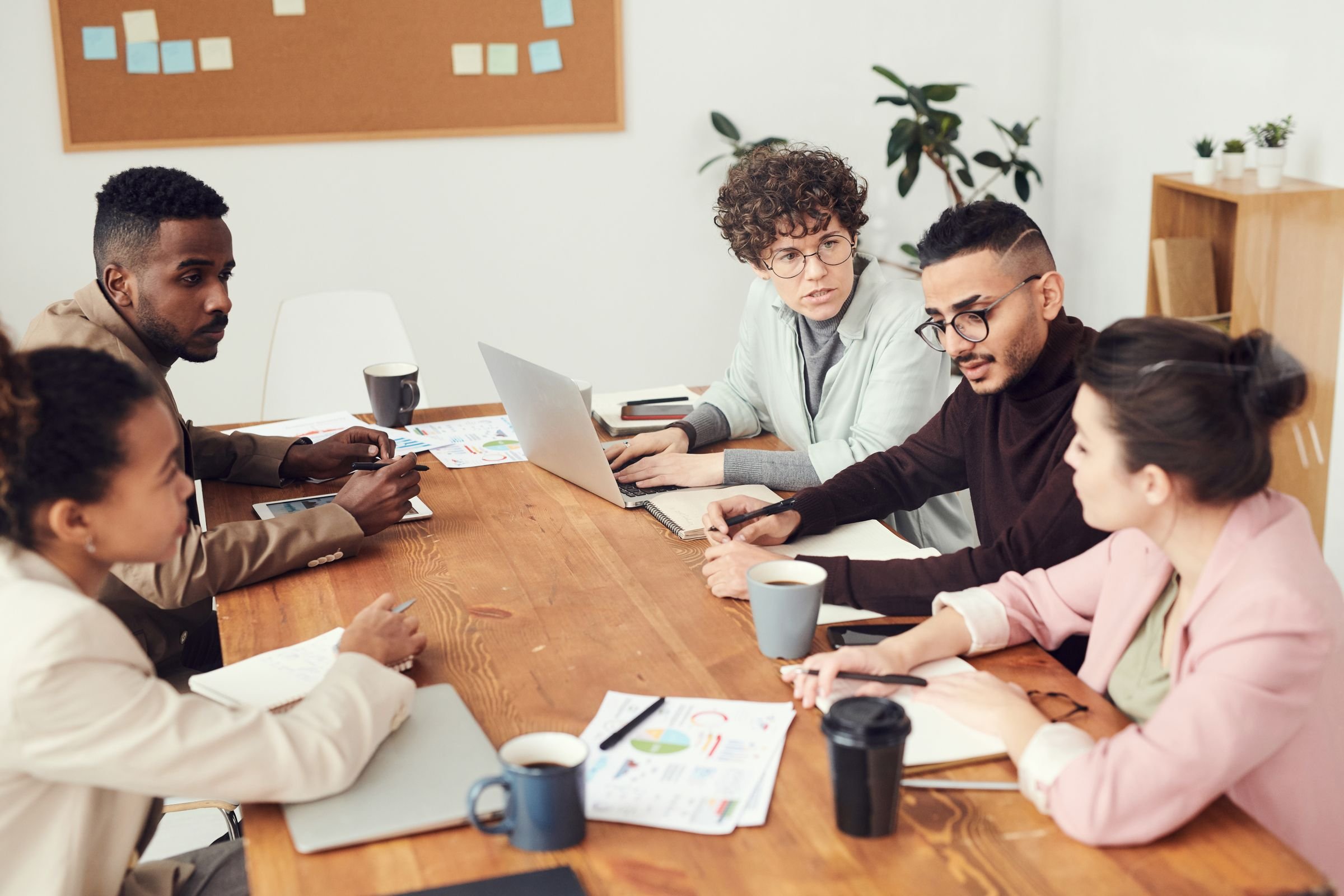A team in discussion around a wooden table in an office